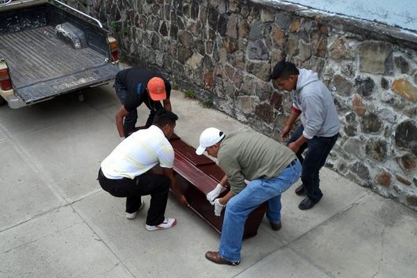 Trabajadores de la morgue trasladan el cadáver a un vehículo particular. (Foto Prensa Libre: Hugo Oliva)<br _mce_bogus="1"/>