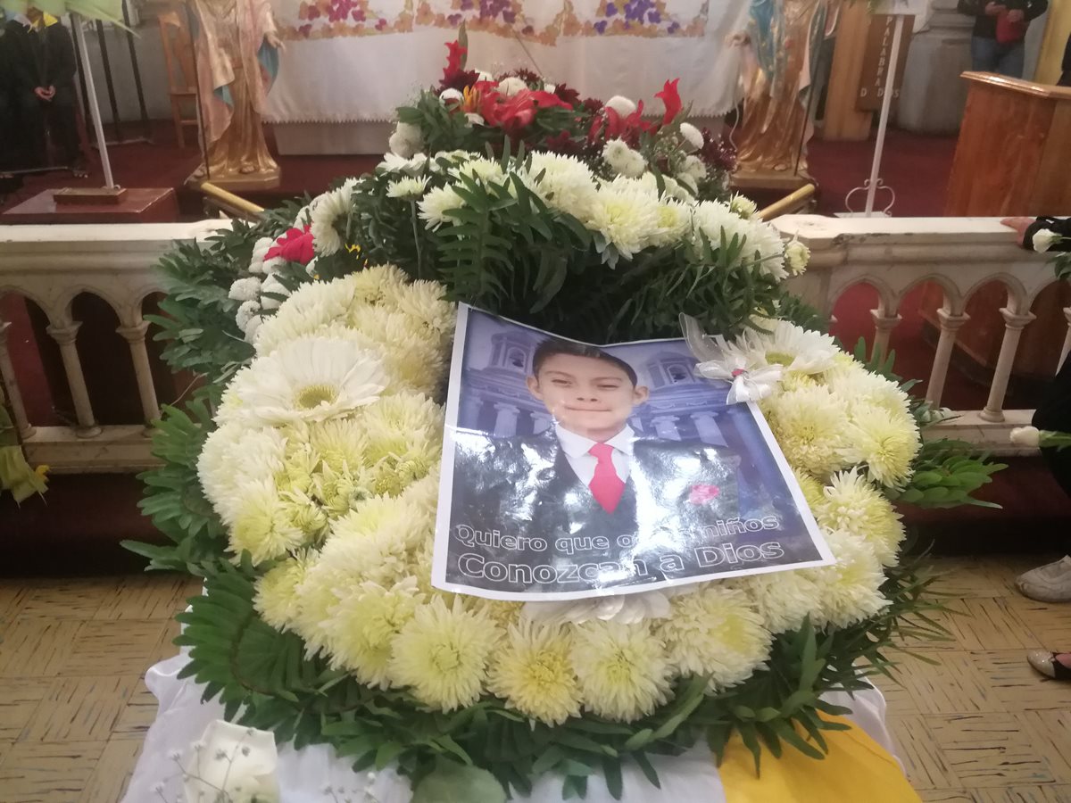 En el ataúd del adolescente los familiares colocaron su fotografía y ofrendas florales para honrar su memoria. (Foto Prensa Libre: Fred Rivera)