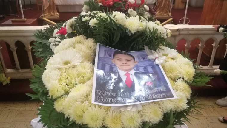 En el ataúd del adolescente los familiares colocaron su fotografía y ofrendas florales para honrar su memoria. (Foto Prensa Libre: Fred Rivera)