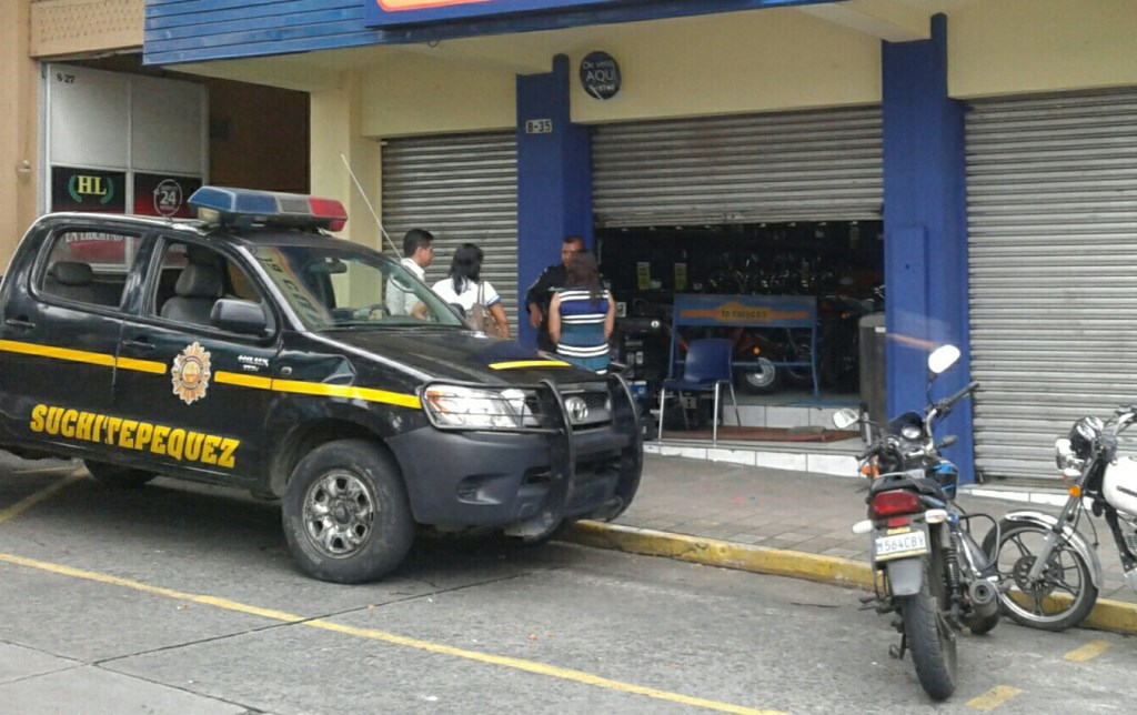 Agentes de la PNC y fiscales del MP resguardan el negocio que fue saqueado en Mazatenango. (Foto Prensa Libre: Melvin Popá)