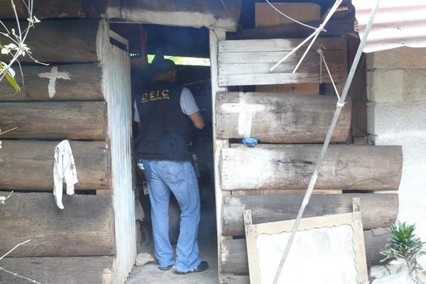 Agentes examinan la vivienda donde ocurrió el homicidio. (Foto Prensa Libre: Edwin Perdomo)
