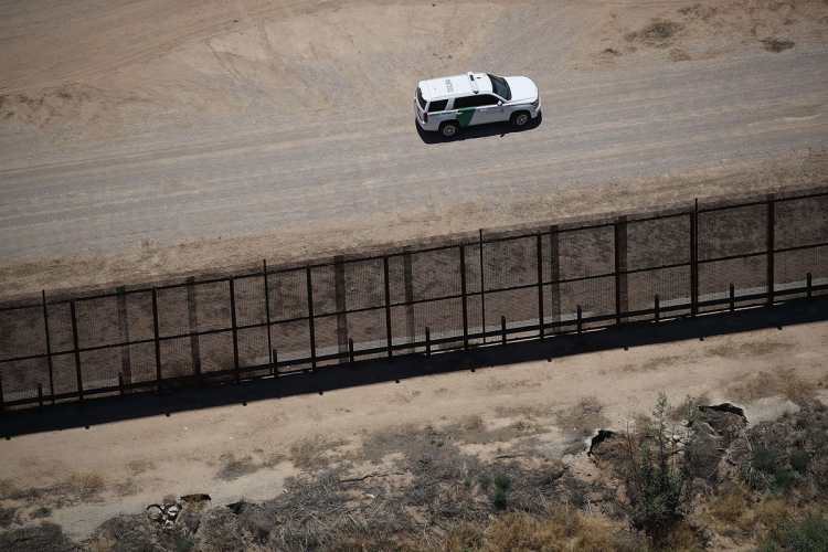 Un automóvil de la policía fronteriza vigila cerca del campamento para niños.