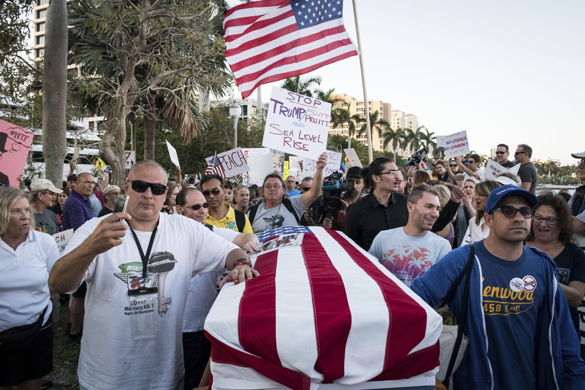En Florida, durante la visita de Trump, activistas simulan la "muerte de la democracia". (Foto Prensa Libre: AP)