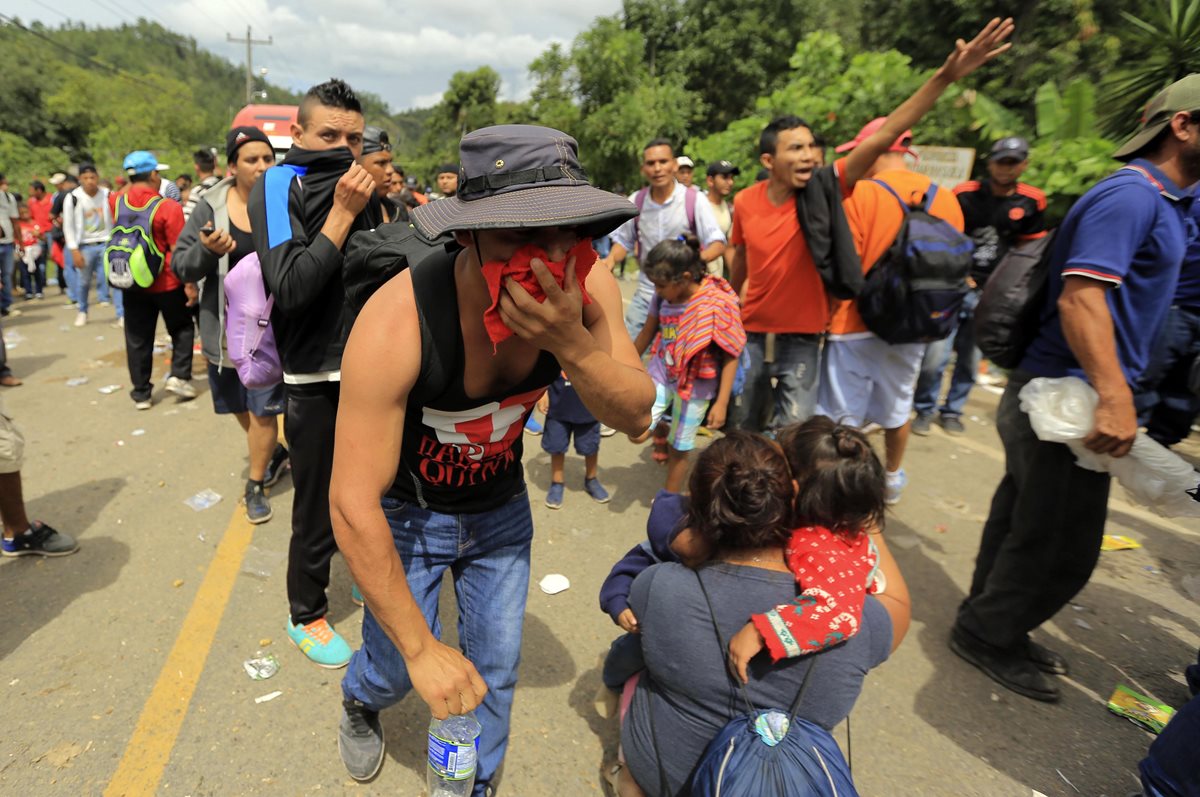 Migrates hondureños intentan cruzar un retén policial en un punto fronterizo entre Honduras y Guatemala. (Foto Prensa Libre: Cortesía agencia Xinhua)