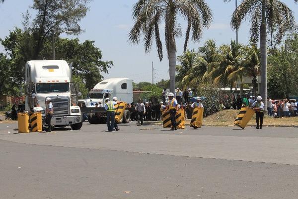Empleados de seguridad de la Portuaria retiran  obstáculos que habían colocado los manifestantes.