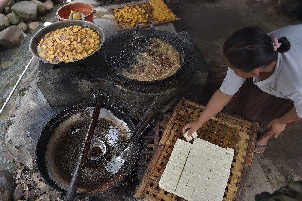 Un trabajador corta la pasta blanca en cuadrados. Así se fabrica el tofu.(AFP).
