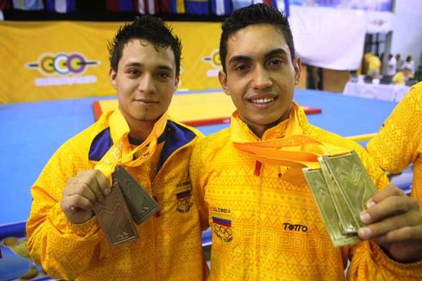 Los pesistas colombianos Habib de las Salas (d) y Carlos Berna (i) posan con sus medallas ganadas en Mayagüez. (Foto Prensa Libre: EFE).