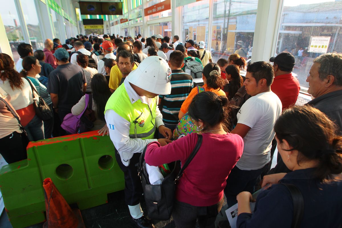 <span style="font-size: 12px;">Un policía municipal revisa la bolsa de una usuaria antes de abordar un bus del Transmetro en la zona 1.( Foto Prensa Libre: Álvaro Interiano)</span>
