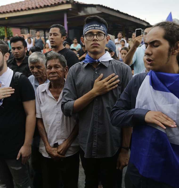 El líder estudiantil universitario, Lesther Aleman (2-d) y otros integrantes del movimiento del 19 de abril, guardan un minuto de silencio por las víctimas protestas en Masaya,Nicaragua. (AFP).