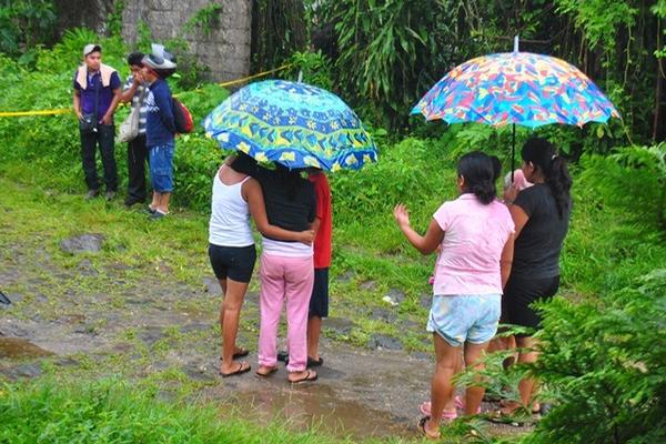Curiosos permanecen en el lugar donde fue encontrado el cadáver de hombre, en San Felipe. (Foto Prensa Libre: Jorge Tizol) <br _mce_bogus="1"/>