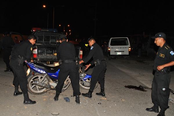 Agentes de la Policía levantan la motocicleta en la que se desplazaba Gilder Augusto Morales Sandoval. (Foto Prensa Libre: Rigoberto Escobar)