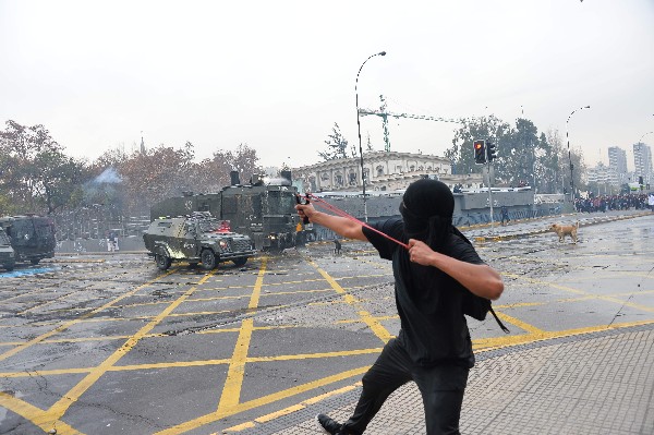 Estudiantes chocan con la Policía antidisturbios en Santiago. (Foto Prensa Libre: AFP)