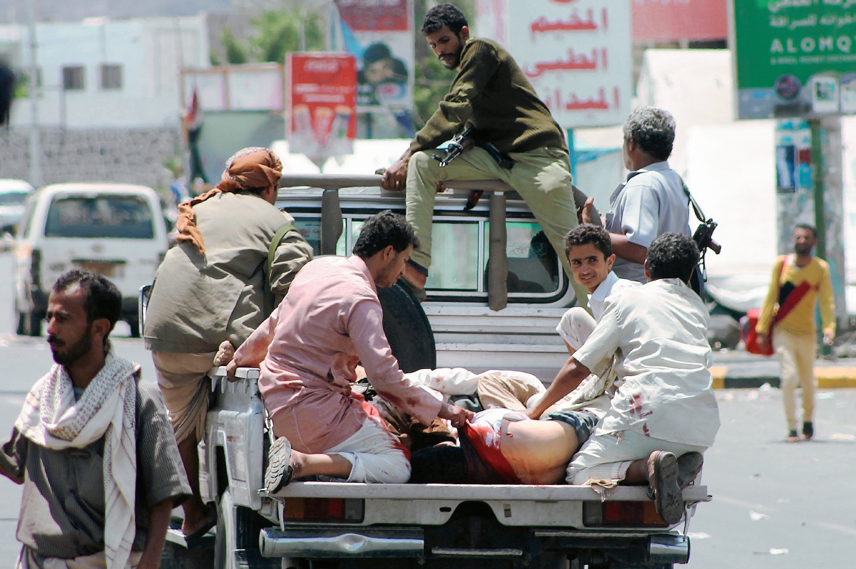 Hombres trasladan a heridos por los bombardeos de los países aliados perpetrados en la capital de Yemen. (Foto Prensa Libre: AFP).
