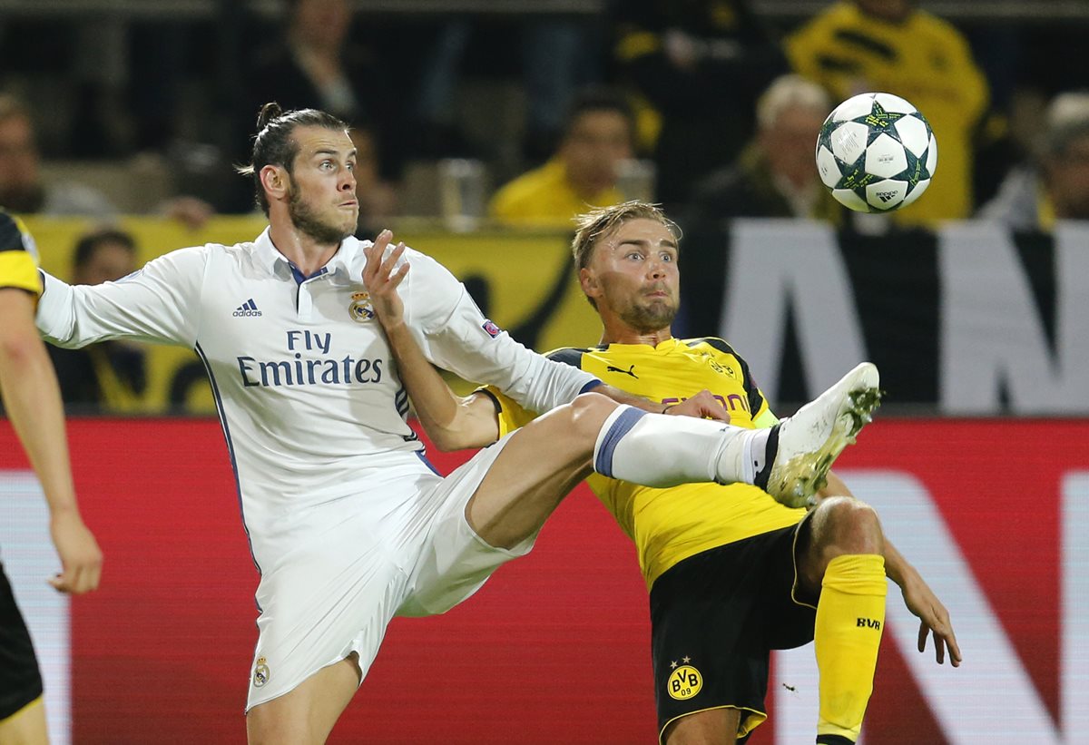 El galés Gareth Bale pelea la pelota con Marcel Schmelzer en una acción del juego que terminó 2-2 entre el Real Madrid y el Borussia Dortmund. (Foto Prensa Libre: AP)