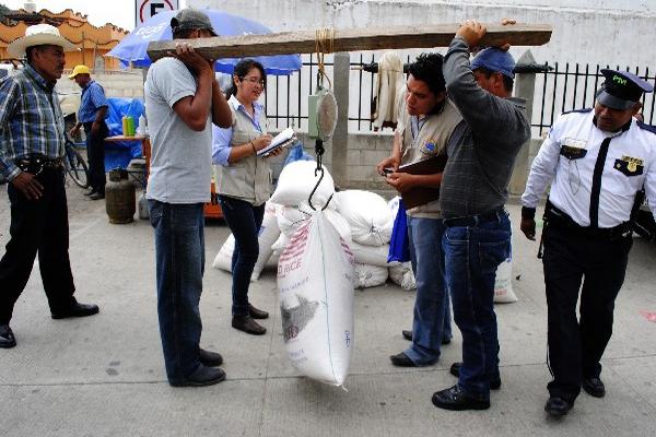 Personal de la Diaco pesa un saco de maíz en  Cubulco, Baja Verapaz.