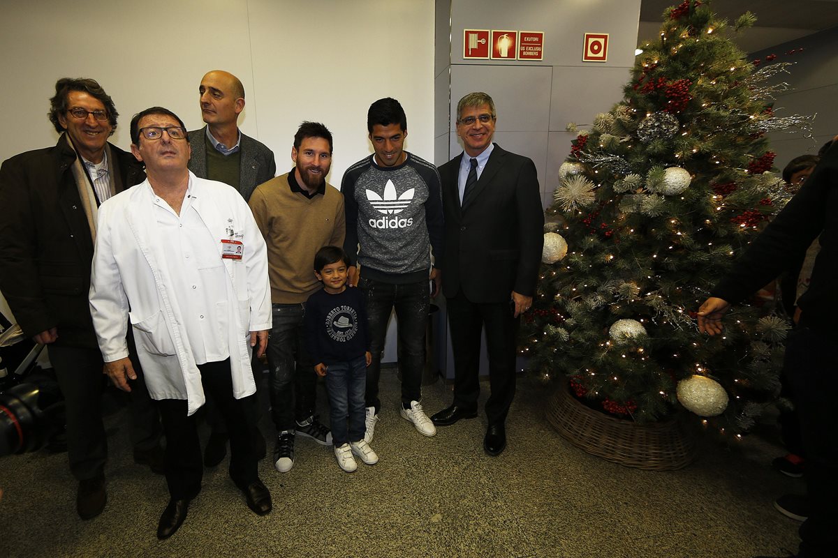 Leo Messi y Luis Suarez captados durante la visita al Hospital de niños de Barcelona, acompañados de los directivos del club Jordi Mestre (d) y Jordi Moix (i), tras el entrenamiento de puertas abiertas realizado este martes en el Mini Estadi. (Foto Prensa Libre: EFE)