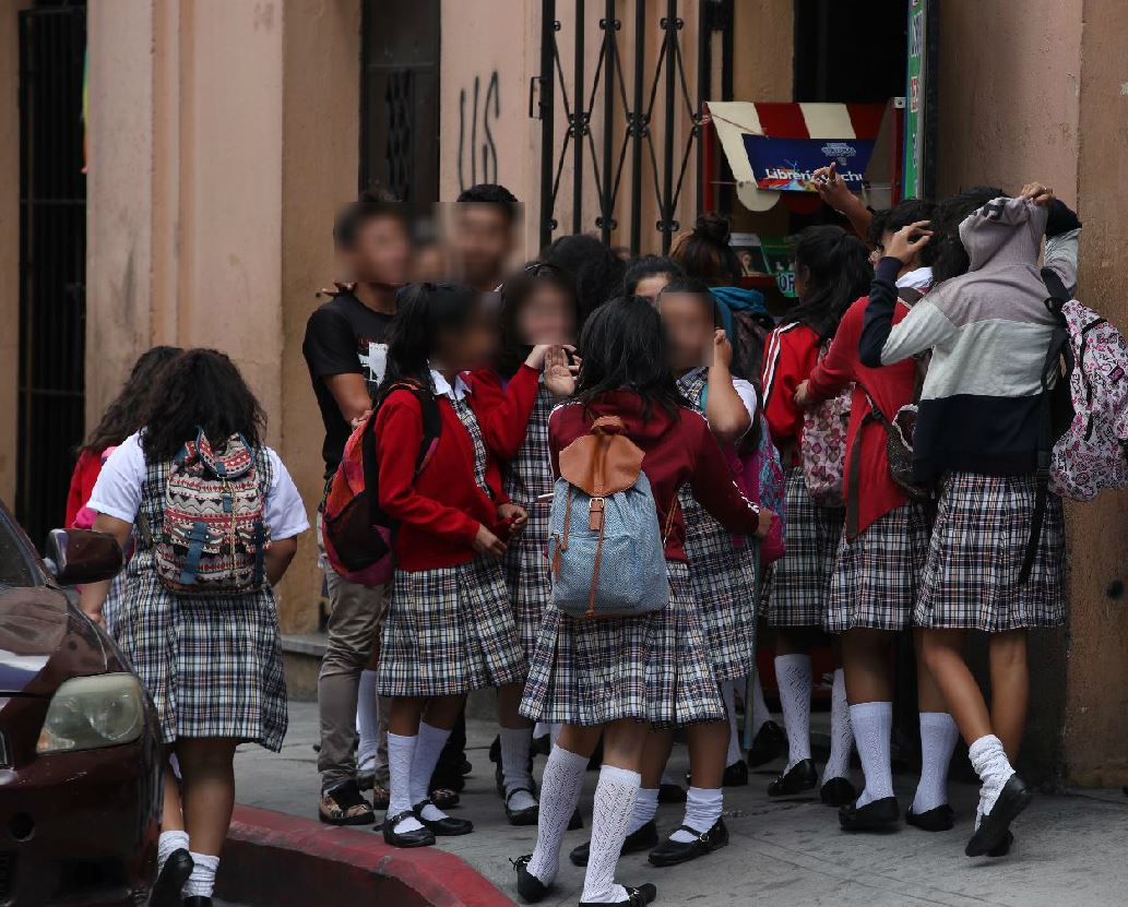 Alumnas del instituto Maria Luisa Samayoa Lanuza, ubicado en la 10a avenida y 9a calle, zona 1, conversan con dos jóvenes con aspecto de pandilleros a la hora de salida. (Foto Prensa Libre: Paulo Raquec)