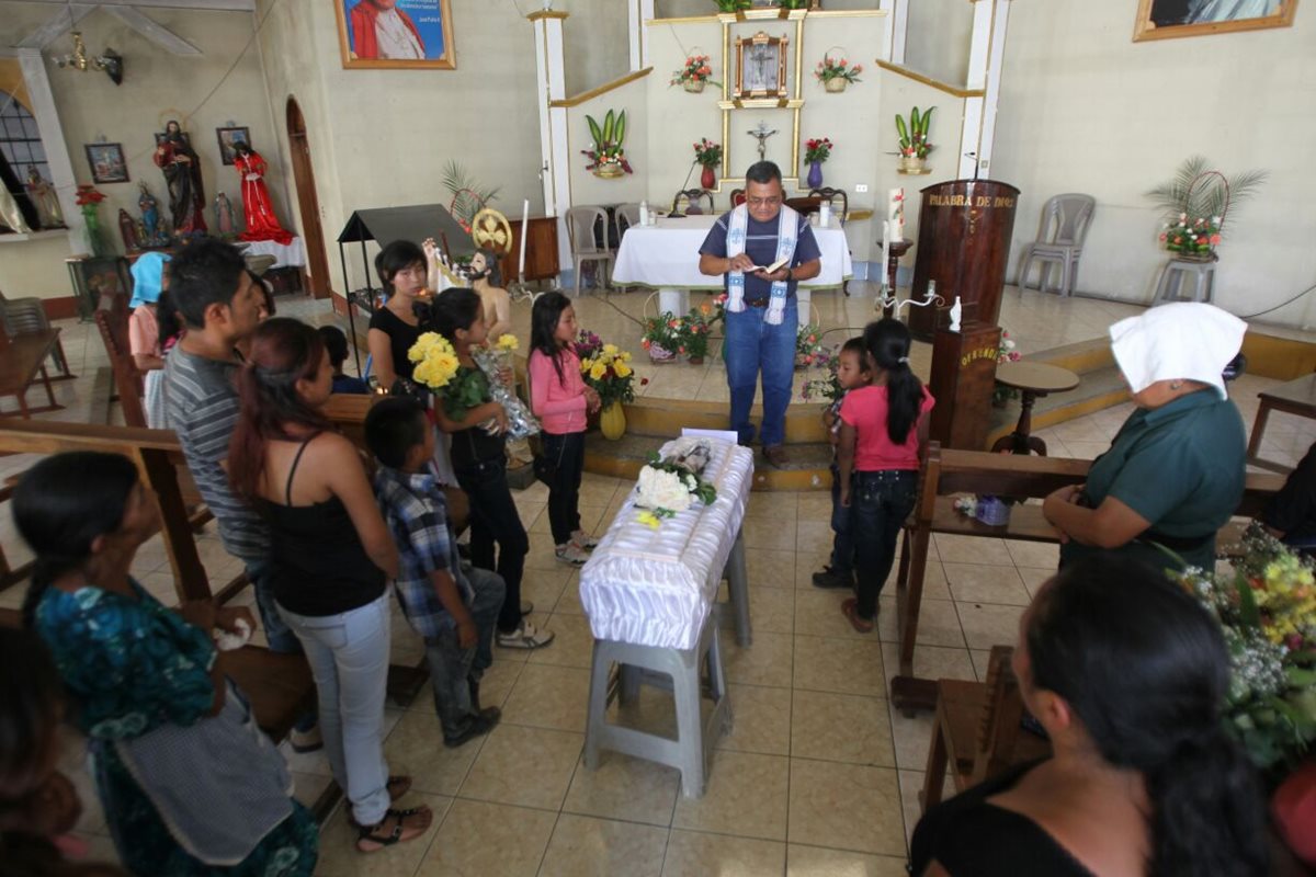 Familia y vecinos asisten a los oficios religiosos previo al sepelio del bebé, en San Pedro Ayampuc. (Foto Prensa Libre: Érick Avila)