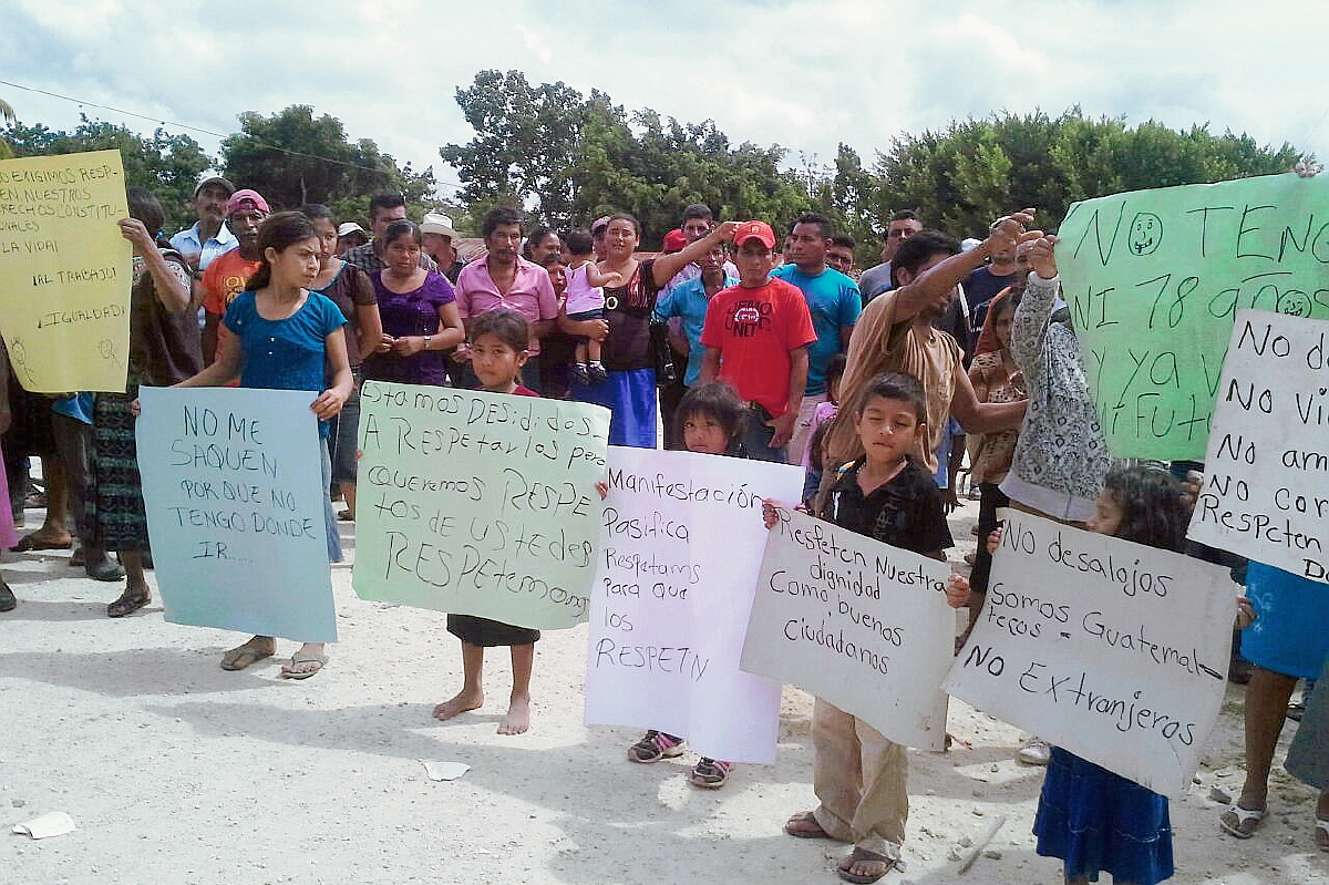 Pobladores de  la Reserva de Biósfera Maya, que se oponen a los desalojos, portaban pancartas. (Foto Prensa Libre: Rigoberto Escobar)