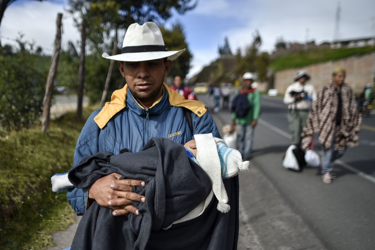 Familias venezolanas son captadas cuando caminan en la carretera Panamericana, Colombia, en su travesía hacia Perú. (Foto Prensa Libre: AFP)