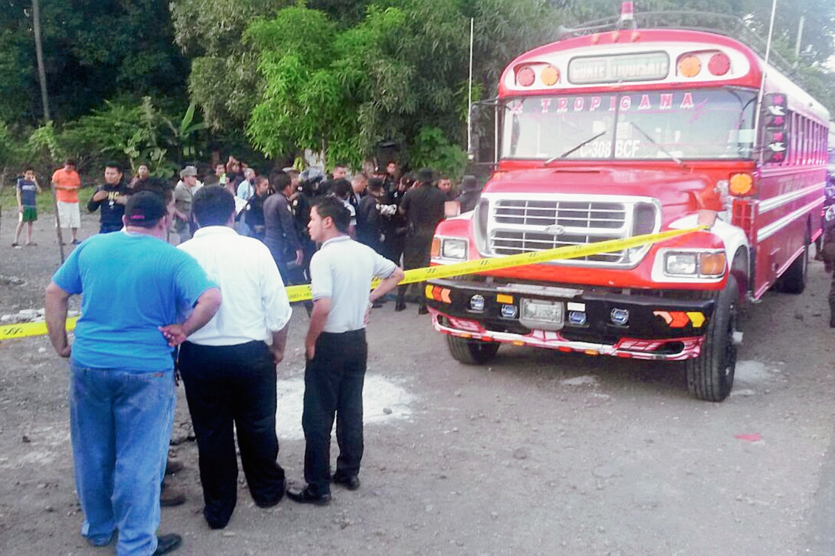 Agentes de la PNC acordonan el autobús que fue asaltado, y donde murió uno de los presuntos delincuentes. (Foto Prensa Libre: Carlos E. Paredes)