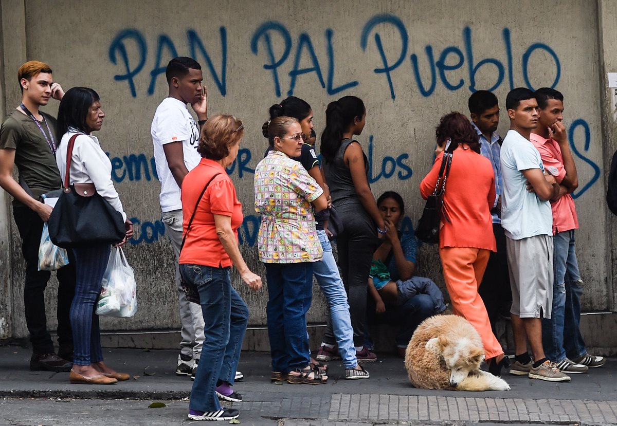 Venezolanos hace fila para tratar de comprar algo de pan en Caracas. (Foto Prensa Libre: AFP)
