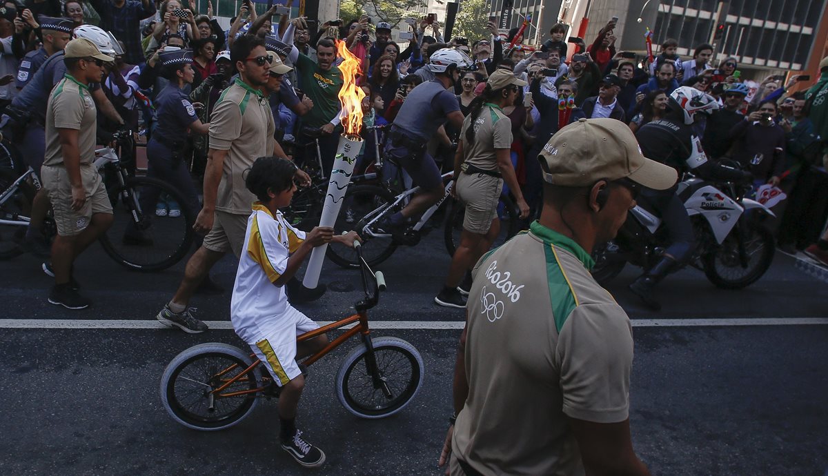 Un niño residente de Sao Paulo porta la llama olímpica. (Foto Prensa Libre: AFP)