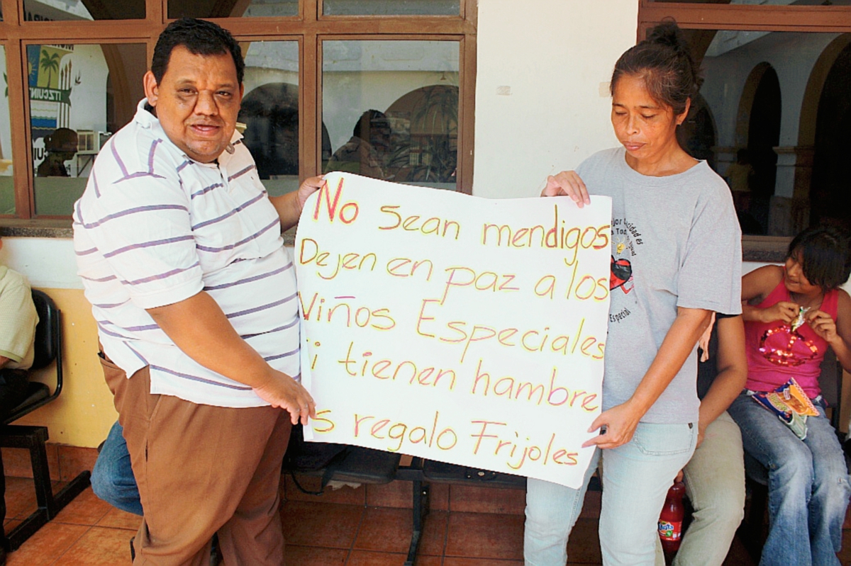 Dos de los afectados muestran un rótulo para rechazar los constantes robos en escuela, en Escuintla. (Foto Prensa Libre: Melvin Sandoval)