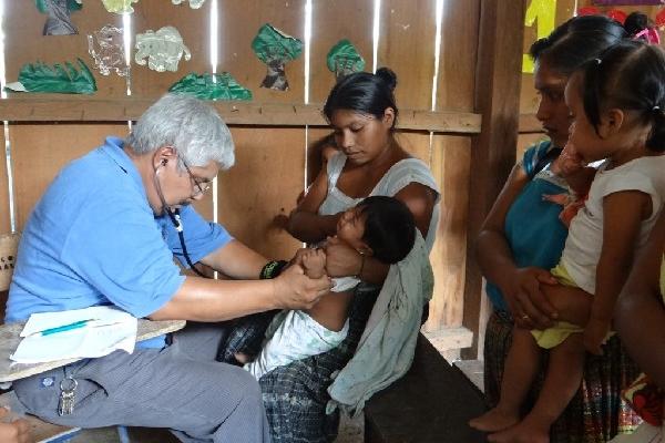 pediatra inyecta a un niño en la aldea Paso Caballos.