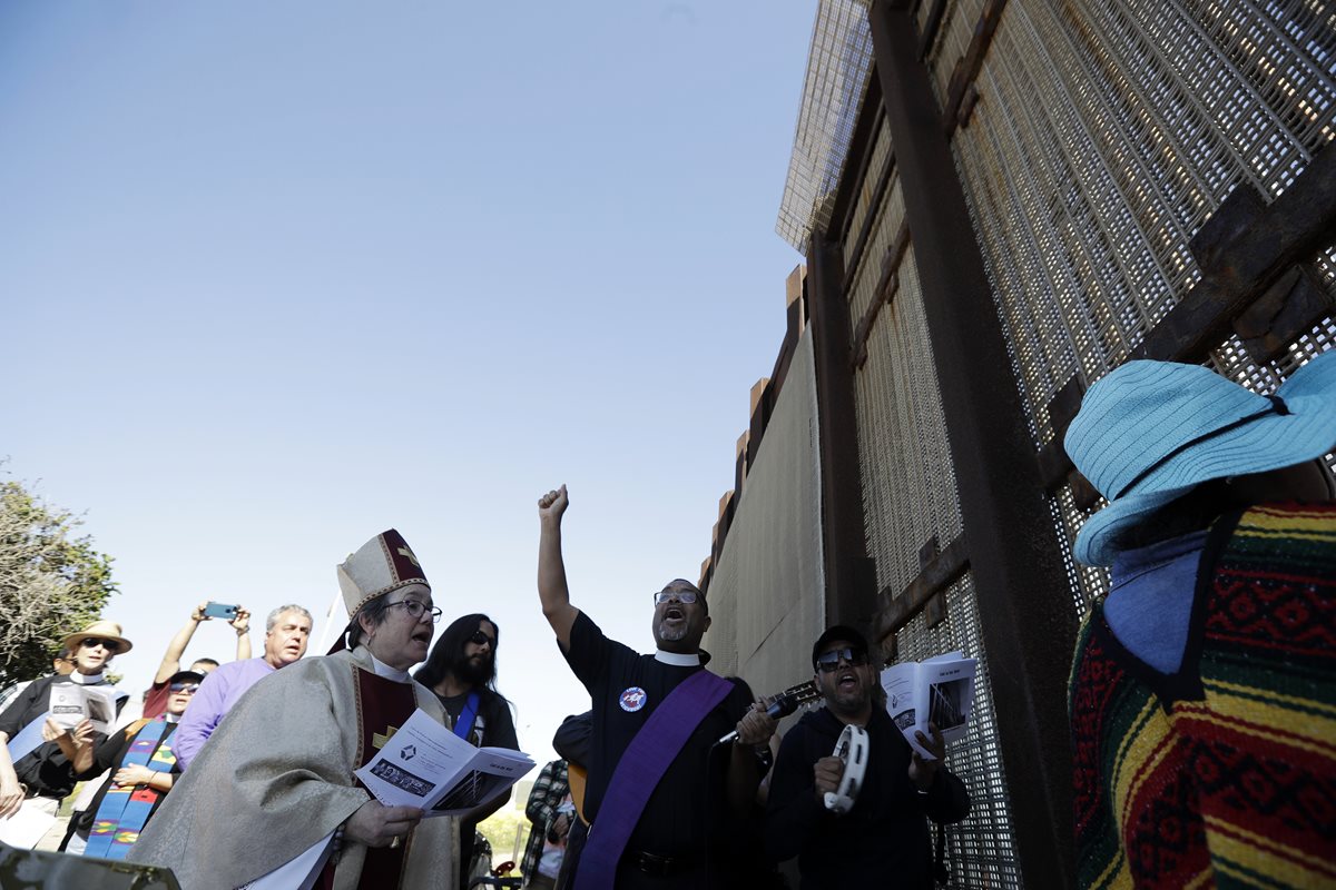 Líderes religiosos dirigen actividad en favor de migrantes en una parte del muro entre EE. UU. y México. (Foto Prensa Libre: AP)