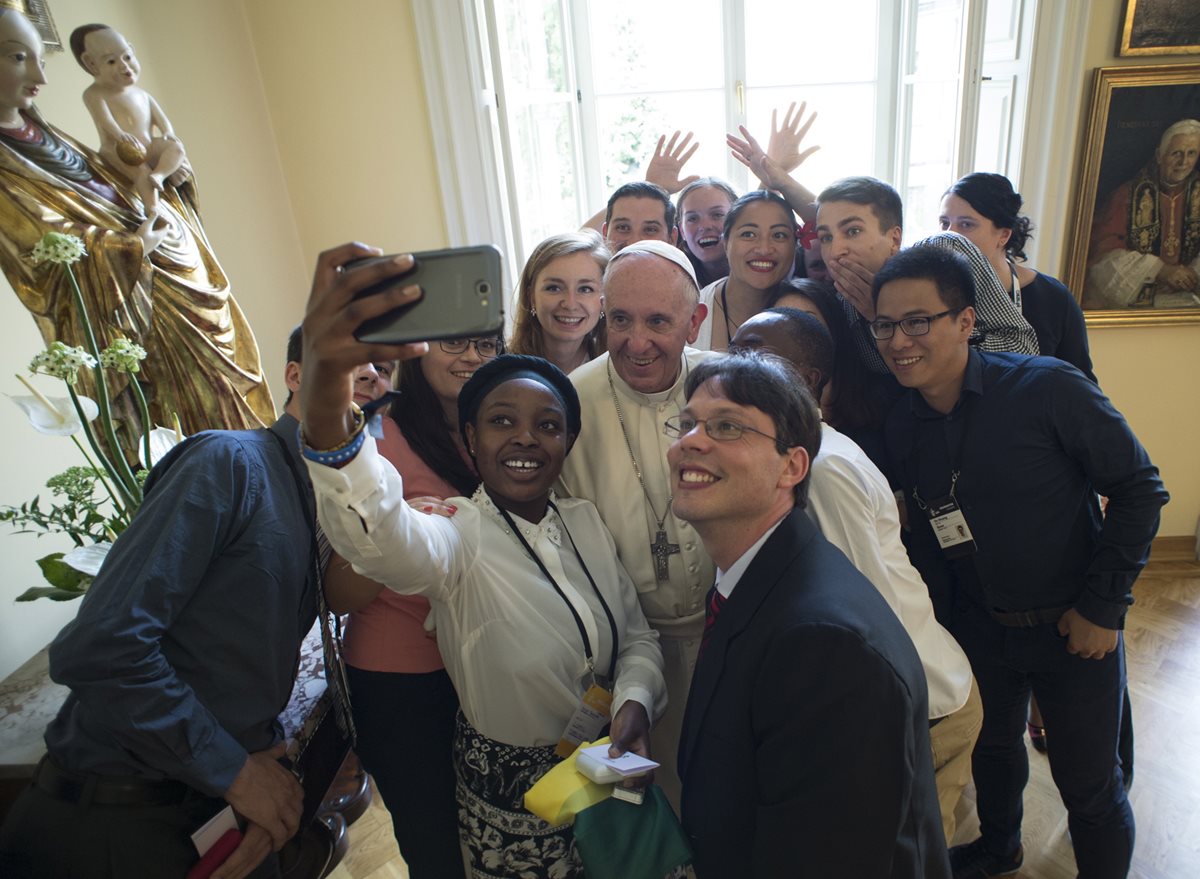 El papa Francisco se toma un selfi con varios jóvenes durante un encuentro en Polonia, donde anunció su viaje a Colombia. (Foto Prensa Libre: AFP).