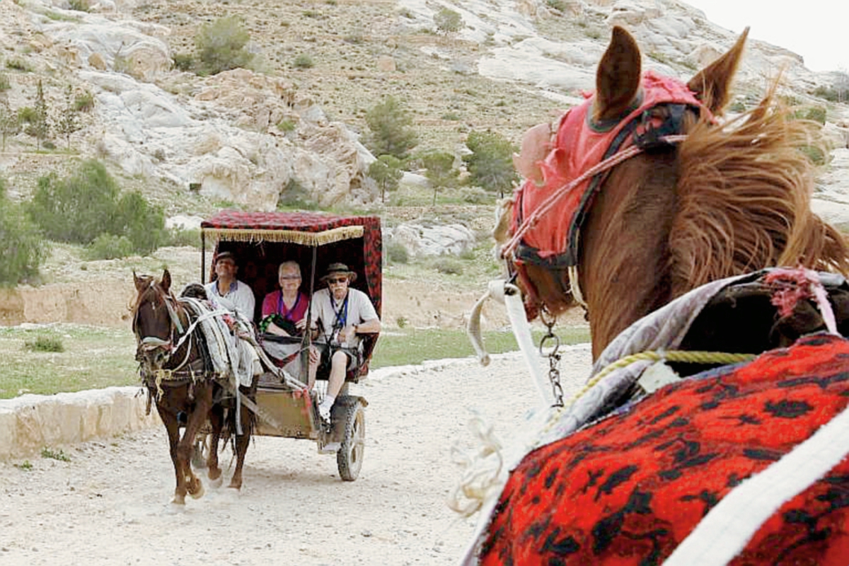 Un caballo jala una carreta con turistas en el camino que conduce a la milenaria Petra. (Foto Prensa Libre: AFP).