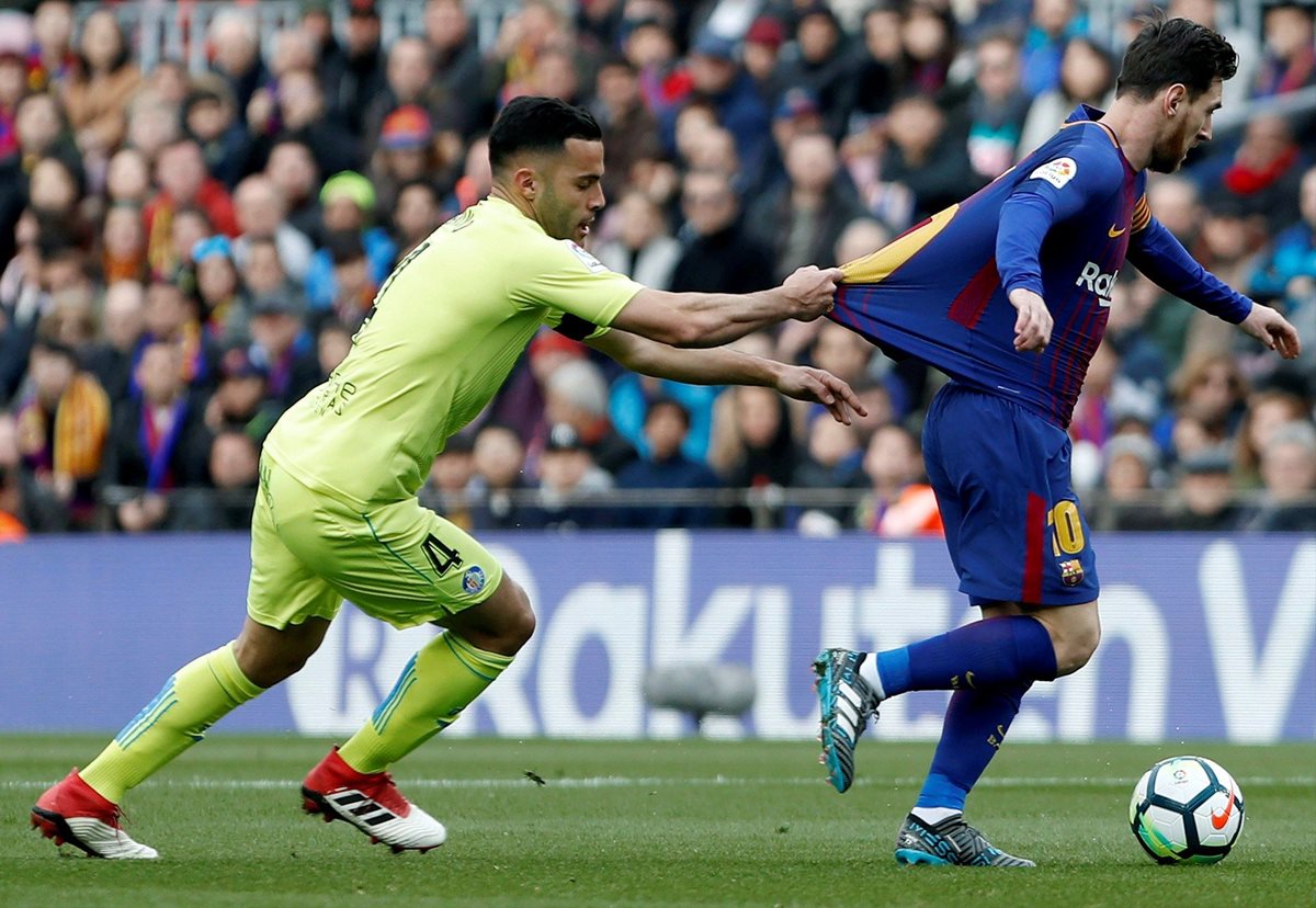 Lionel Messi intenta escaparse del defensa del Getafe Bruno González.(Foto Prensa Libre: EFE)