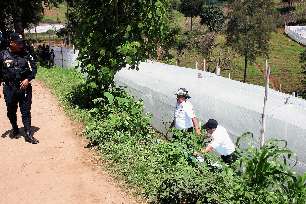 Socorristas observan el cuerpo sin vida de un hombre, en Sumpango, Sacatepéquez. (Foto Prensa Libre: Renato Melgar)