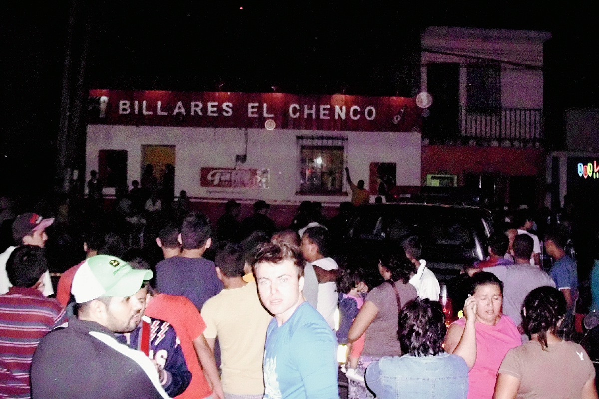 Vecinos de la zona 4 de Sanarate, El Progreso, se aglomeran frente al billar "el Chenco", donde murió un hombre a balazos. (Foto Prensa Libre: Héctor Contreras)