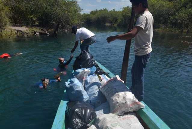 Lancheros transportan en lancha parte de la basura encontrada en la laguna Cráter Azul. (Foto Prensa Libre: Cortesía).