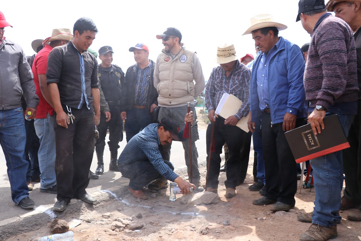 El alcalde auxiliar de la aldea Tuichán, Ixchiguán, Gilberto Chávez, se sostiene de su vara edil mientras marca en el suelo una línea divisoria. (Foto Prensa Libre: Whitmer Barrera)