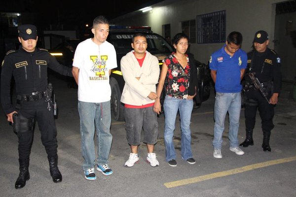 Policías custodian a los cuatro detenidos que huyeron en un taxi con armas y municiones. (Foto Prensa Libre: PNC)