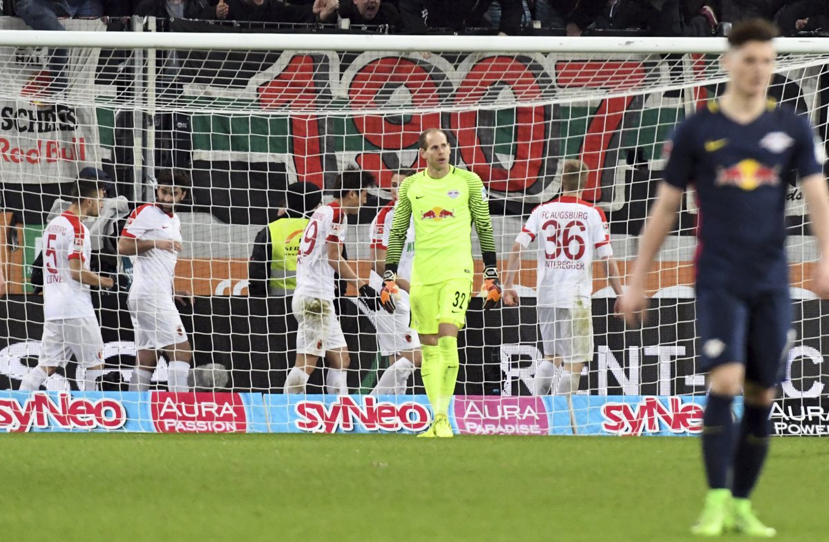 Los jugadores del Leipzig se lamentan mientras los del Ausburgo festejan una de las anotaciones. (Foto Prensa Libre: AFP)