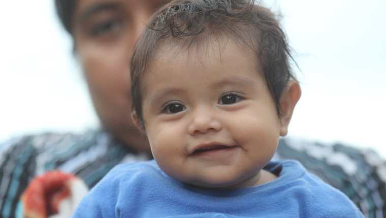 Esmeralda López Pojoy, de seis meses, sonríe en brazos de su madre. La pequeña sobrevivió junto a su familia a la erupción del Volcán de Fuego. (Foto Prensa Libre: Erick Ávila)