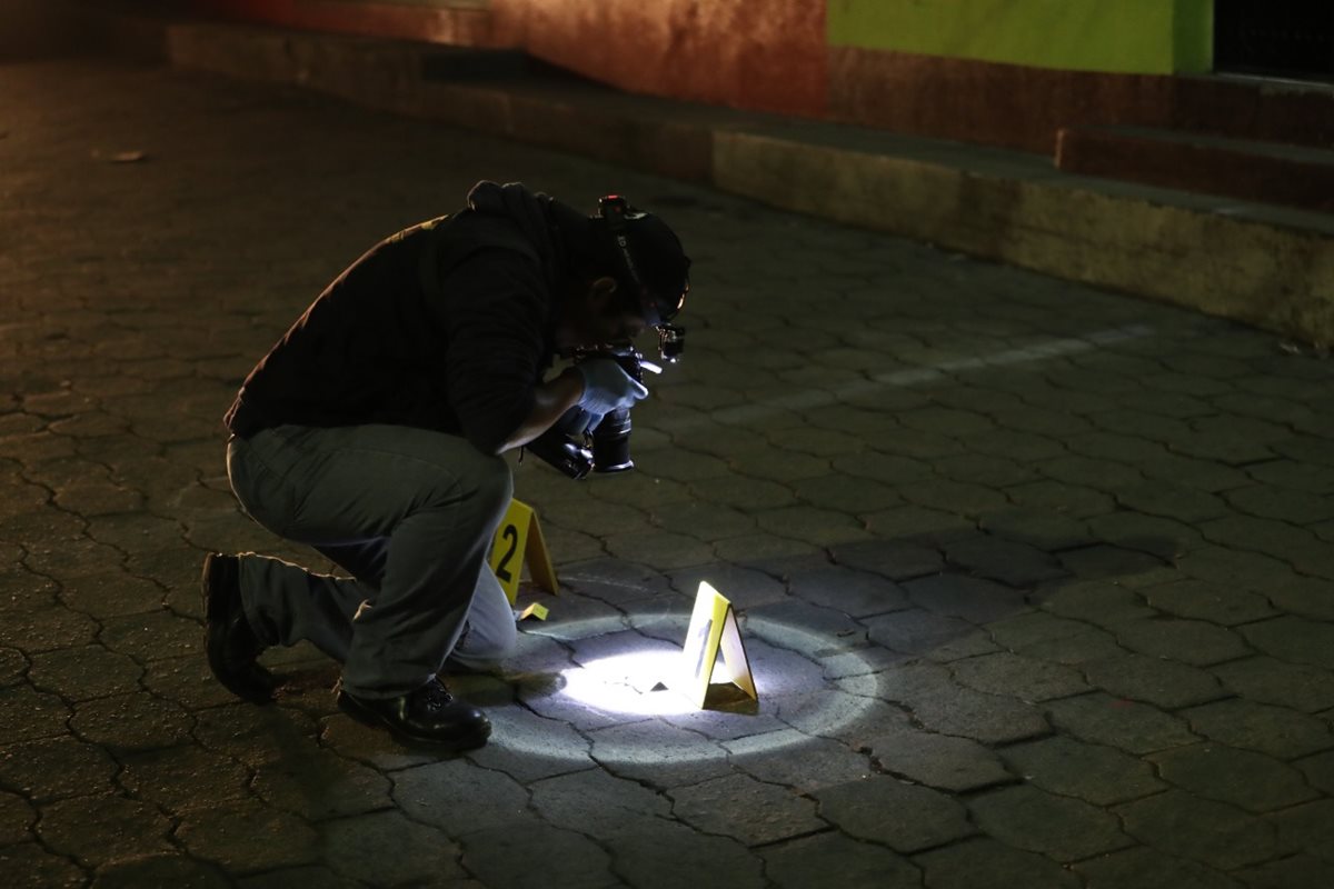 Un investigador del Ministerio Público recaba evidencias donde un hombre murió baleado en la zona 3. (Foto Prensa Libre: Fred Rivera)