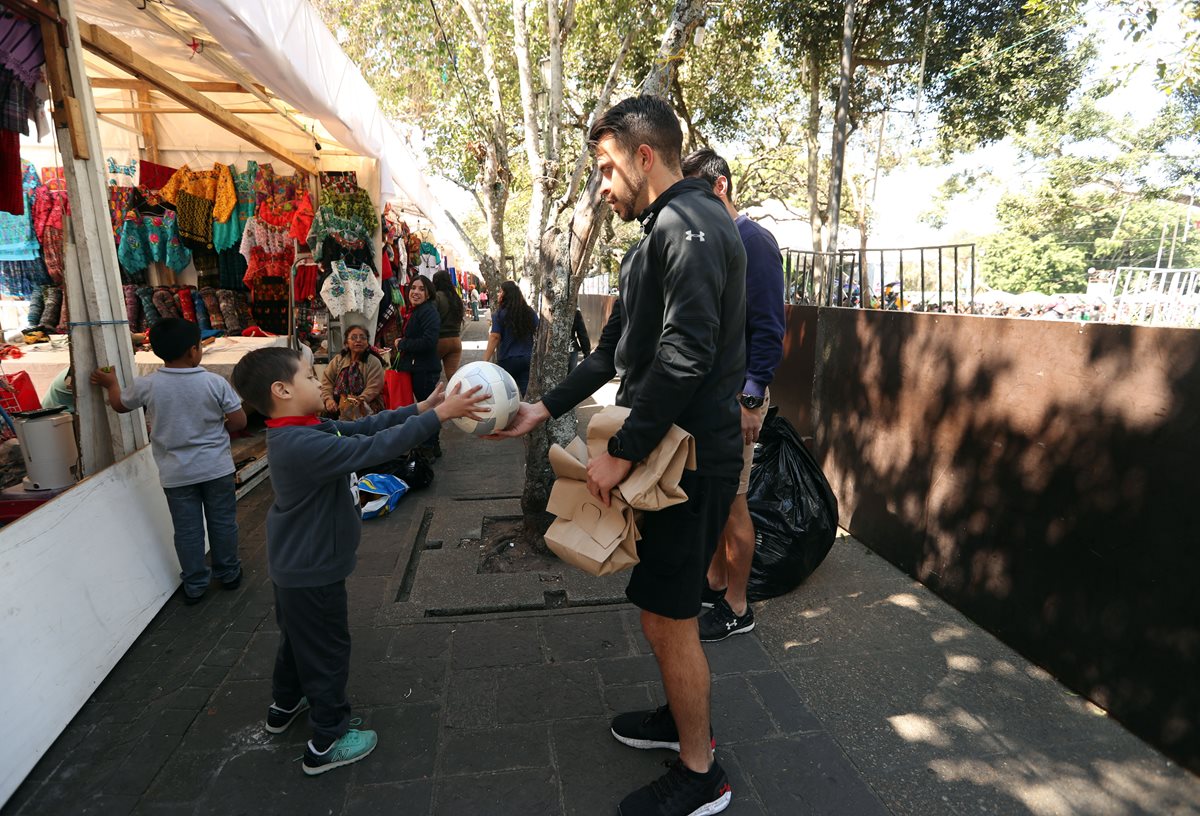 Saravia le regala un balón de futbol a un niño en zona 1. (Foto Prensa Libre: Jeniffer Gómez)