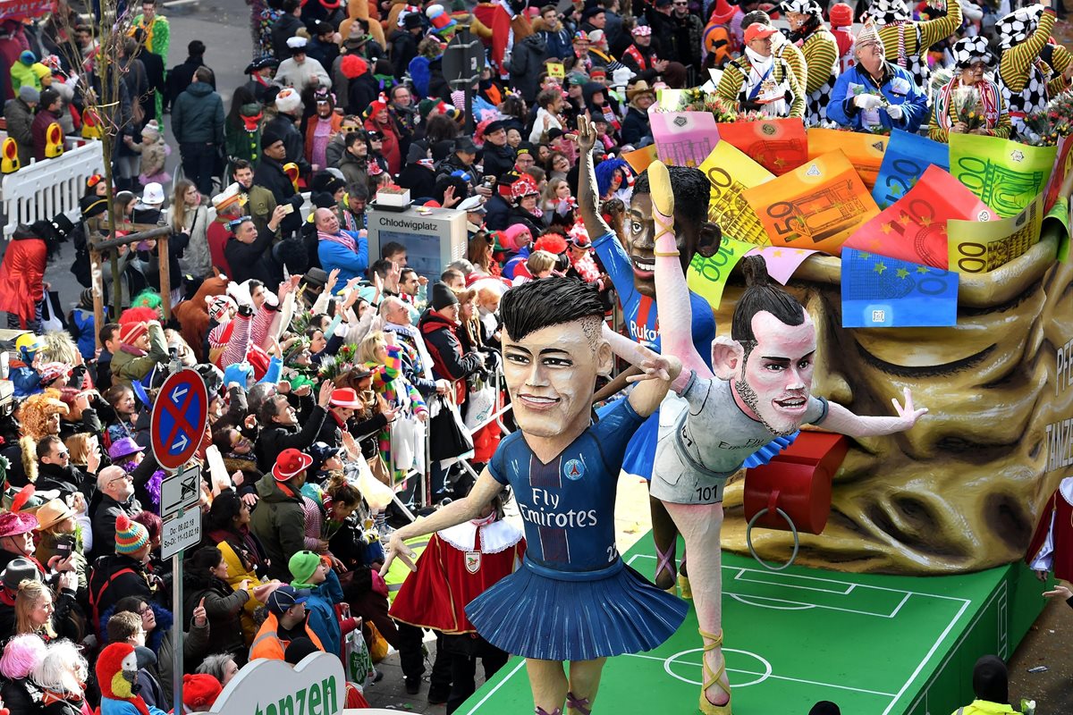 Una carroza protagonizada por el futbolista brasileño Neymar Jr., del PSG, el galés Gareth Bale, del Real Madrid, y el francés Ousmane Dembele, del FC Barcelona, participa en un desfile de carnaval en Colonia (Alemania). (Foto Prensa Libre: EFE)