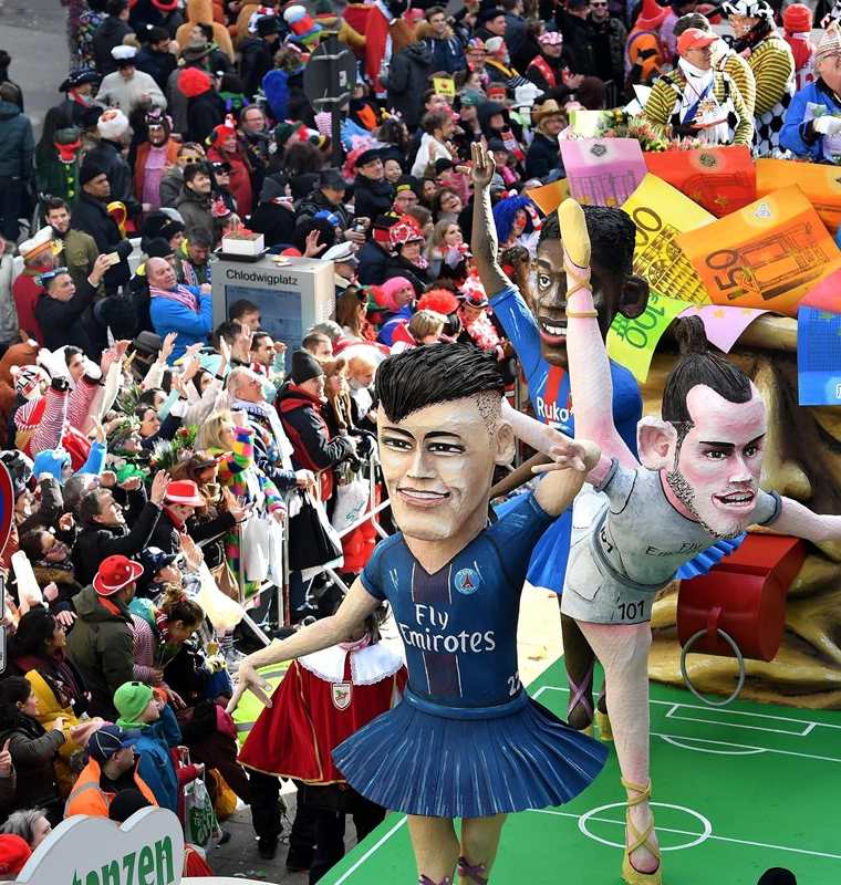Una carroza protagonizada por el futbolista brasileño Neymar Jr., del PSG, el galés Gareth Bale, del Real Madrid, y el francés Ousmane Dembele, del FC Barcelona, participa en un desfile de carnaval en Colonia (Alemania). (Foto Prensa Libre: EFE)