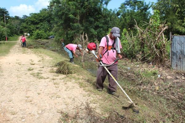 Empleados de la comuna de San Benito, Petén, y vecinos limpian cunetas y cauce de arroyos.