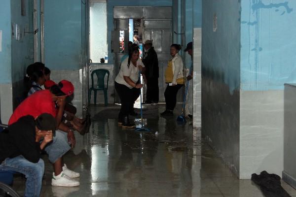 Una empleada del Hospital Nacional de Jalapa saca con una escoba el agua acumulada en el área de emergencias. (Foto Prensa Libre: Hugo Oliva)