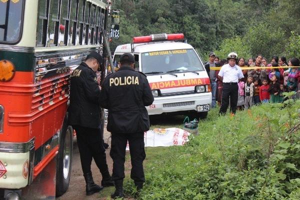 El cadáver  de la mujer quedó a un costado del autobús  que fue asaltado en la ruta Interamericana, en Chupol, Chichicastenango. (Foto Prensa Libre: Ángel Julajuj)