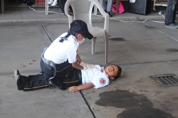 Dos niñas que se graduaron de bombero hacen una demostración de primeros auxilios. (Foto Prensa Libre: Édgar Domínguez)  <br _mce_bogus="1"/>
