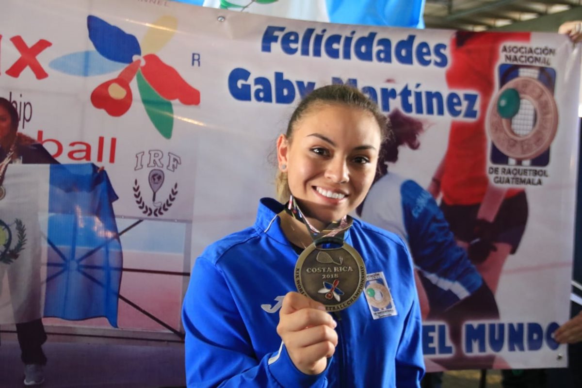 Ana Gabriela Martínez muestra la medalla que la acredita como campeona del mundo en raquetbol femenino. (Foto Prensa Libre: COG)