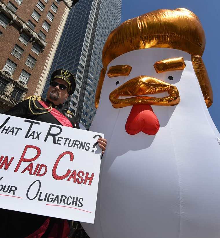 Un manifestante vestido de general ruso posa junto a una gallina gigante de Donald Trump en la marcha que exige la declaración de impuestos del presidente de EE.UU. (Foto Prensa Libre: AFP)